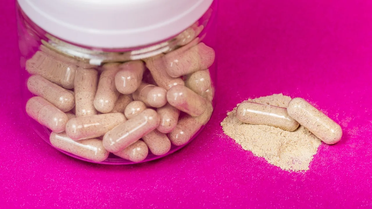 Capsules beside an open plain jar