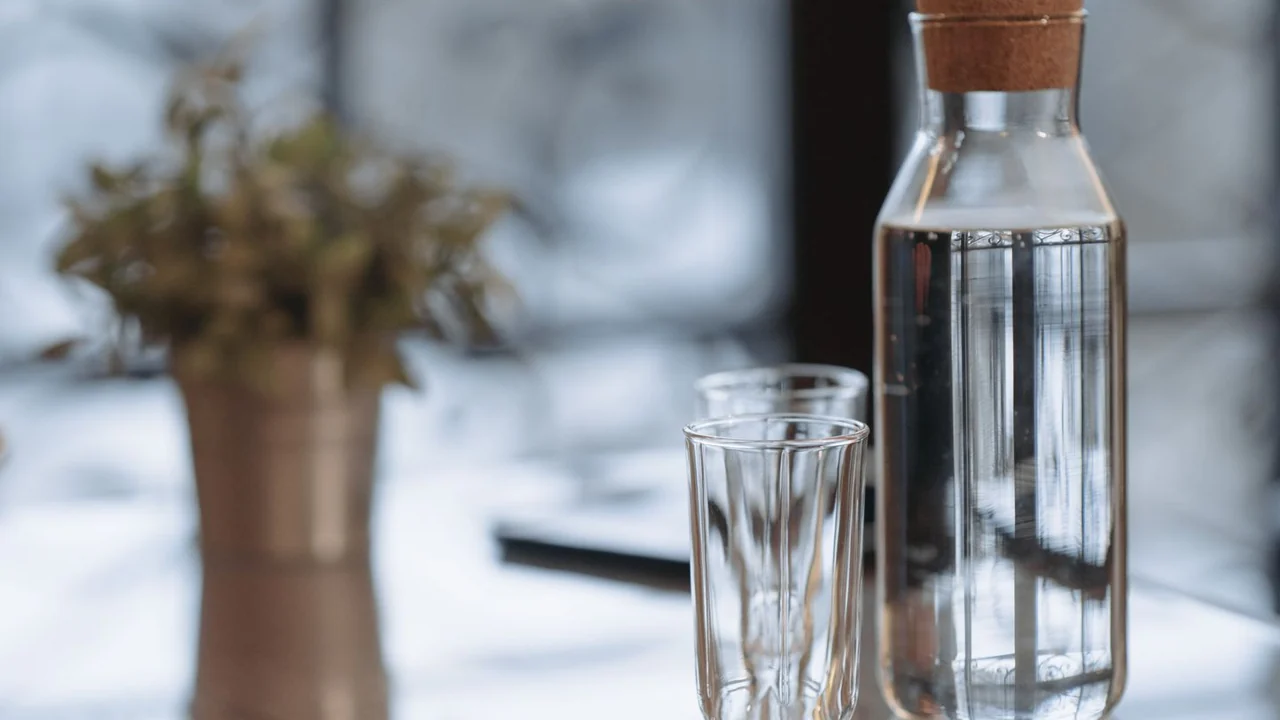 A clear water bottle and an empty glass on a table