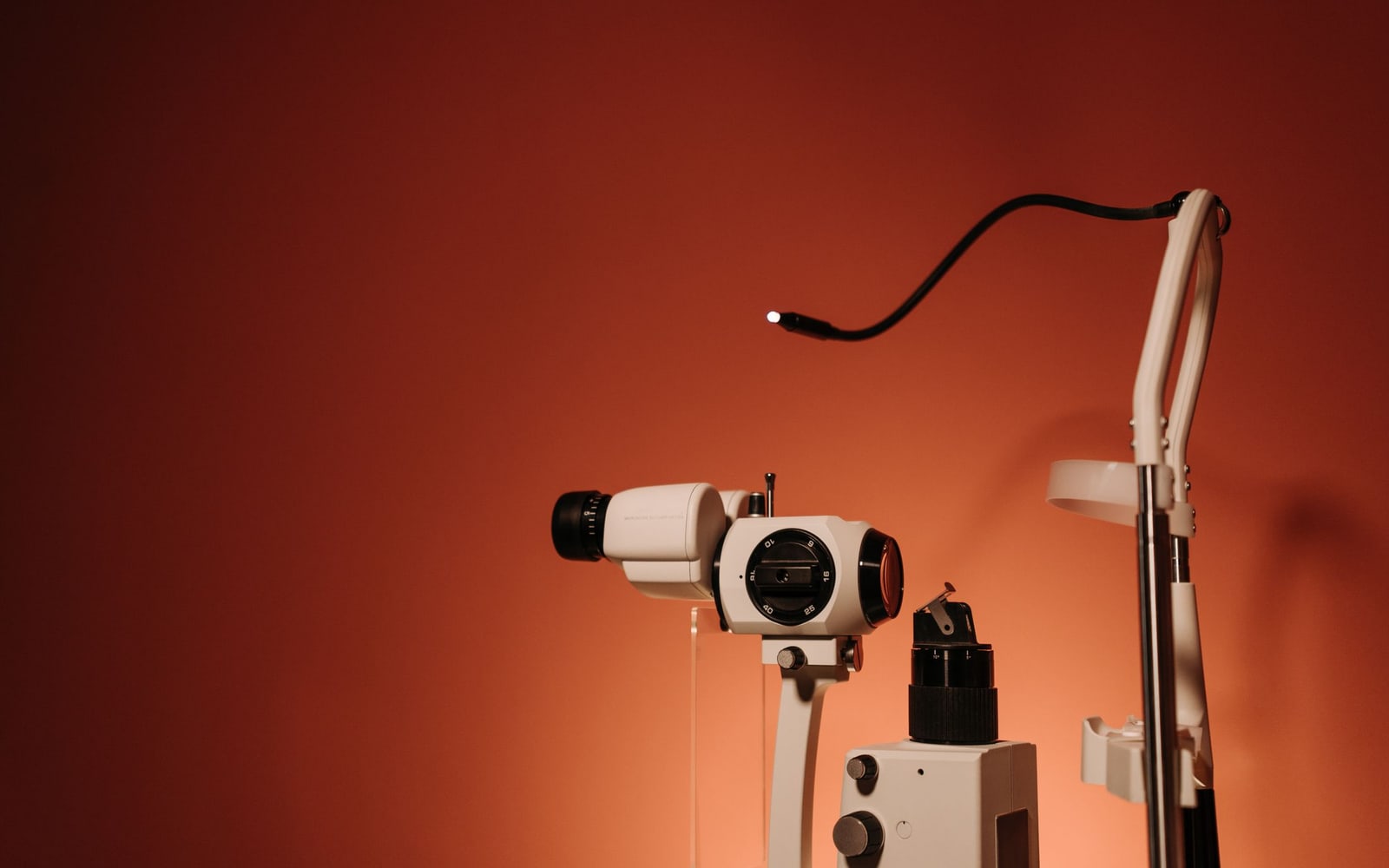 A slit lamp with fine optics on a brown background, ideal for healthcare promotions.