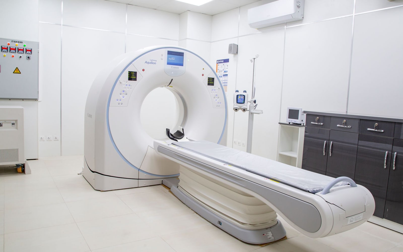 A medical scanner and examination table in a bright room.