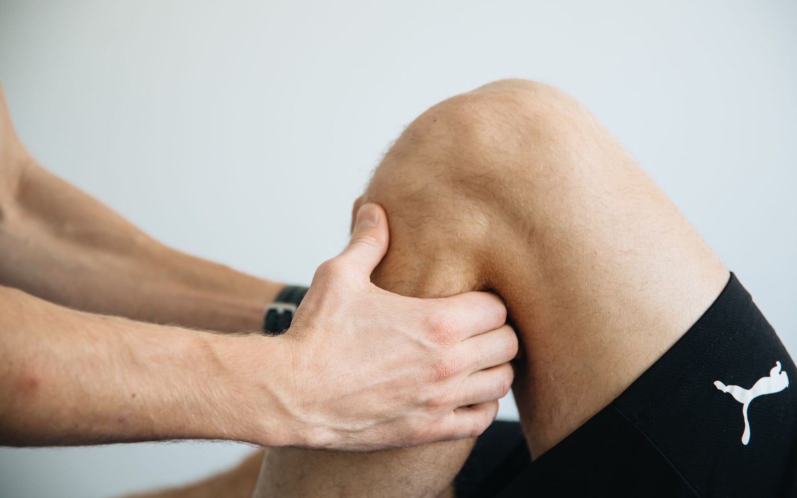Hands assessing a bent knee.