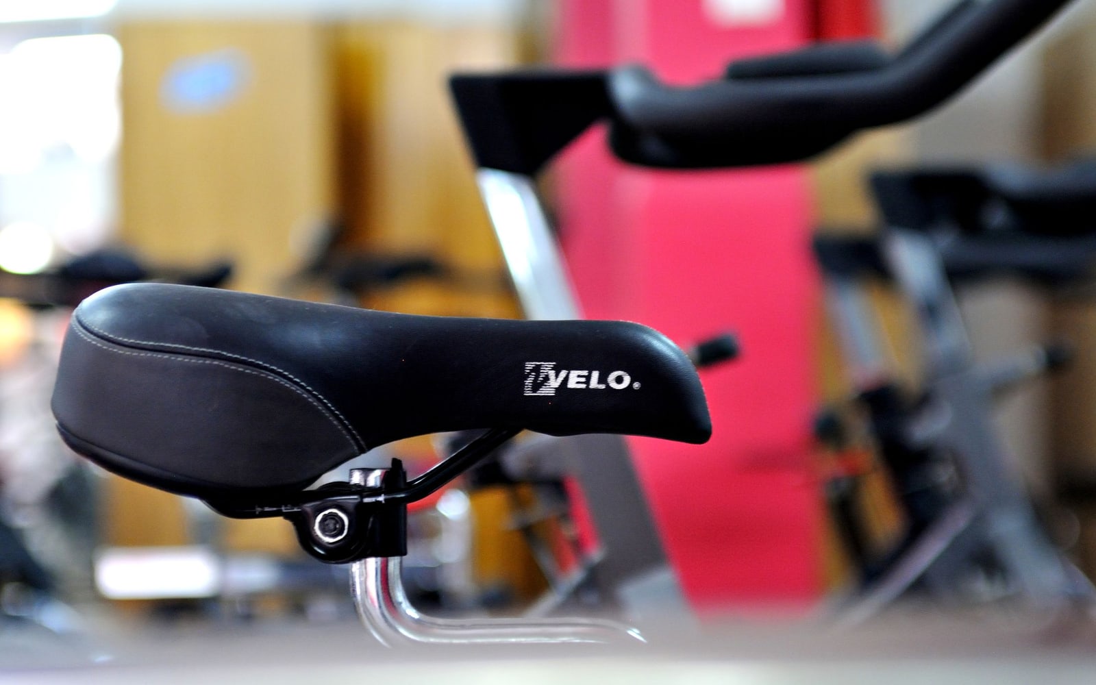 Close-up of a stationary bicycle saddle in a gym.